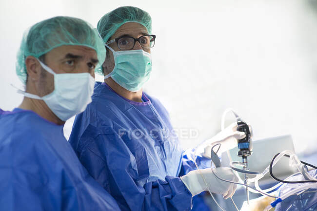 Orthopedic surgeon with male colleague operating in emergency room at hospital — Stock Photo