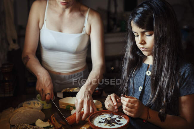 Madre e figlia preparare la colazione mentre in piedi in cucina a casa — Foto stock