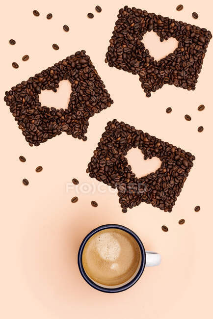 Studioaufnahme einer Tasse Kaffee und gerösteter Kaffeebohnen in Form von Online-Chat-Blasen — Stockfoto