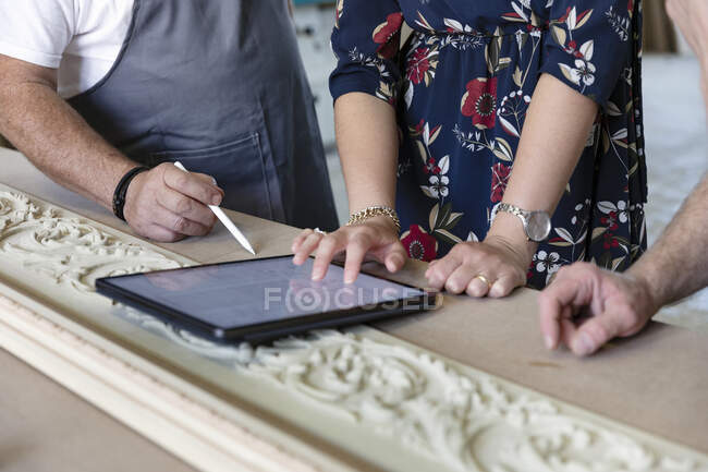 Menuisier et designer utilisant une tablette numérique à l'atelier — Photo de stock