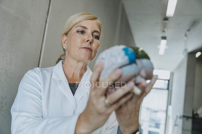 Женщина с разноцветным искусственным мозгом, стоящая в коридоре клиники — стоковое фото