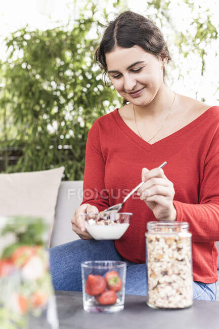 Smiling woman holding preparing oatmeal while sitting at backyard — Stock Photo