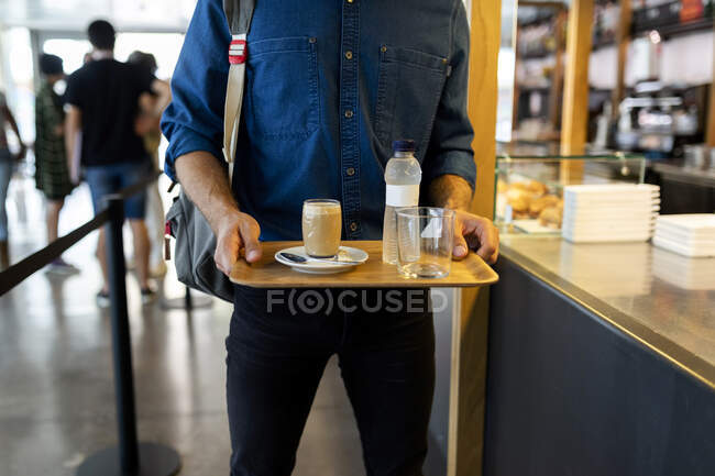Empresário com bebidas refrescantes na bandeja no café — Fotografia de Stock