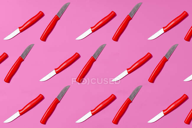 Table knives arranged on pink background — Stock Photo