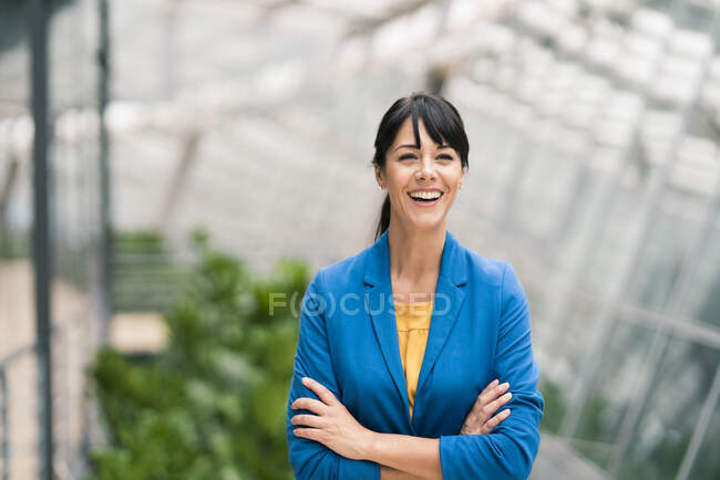 Empresária feliz com braços cruzados no escritório — Fotografia de Stock