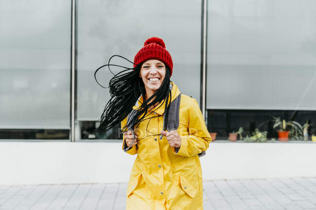 Mujer vistiendo impermeable amarillo de pie en la calle — Cambios, 30 40 años - Stock Photo #481510830