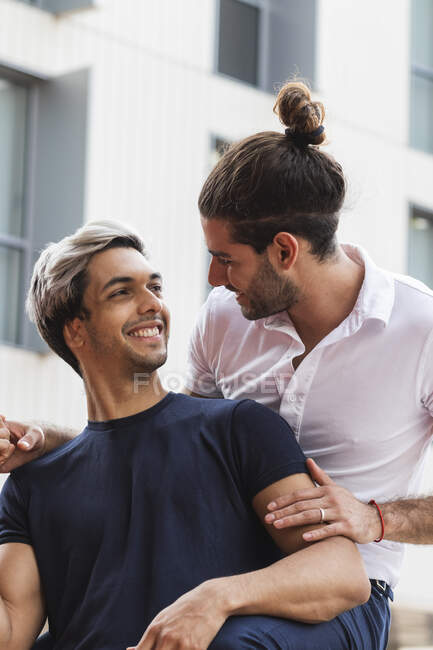 Усміхнений чоловік дивиться на гей-партнера проти будівництва в місті — стокове фото
