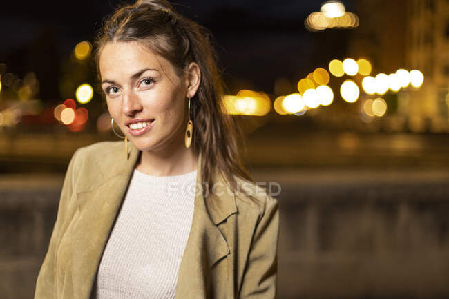 Mujer joven sonriendo de pie al aire libre - foto de stock