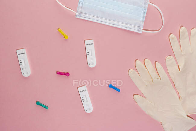 Studio shot of COVID-19 rapid diagnostic tests, pair of surgical gloves and protective face mask — Stock Photo