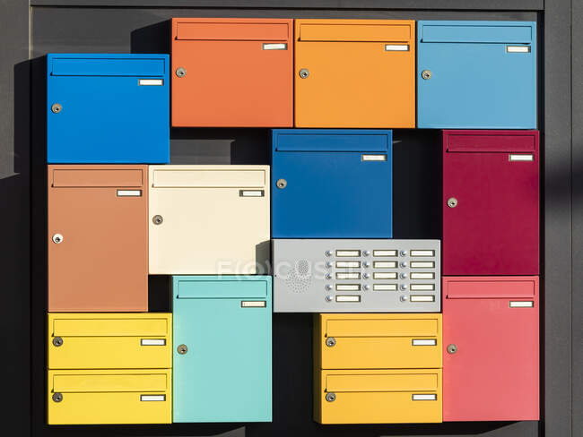 Домофон в оточенні різнокольорових поштових скриньок — стокове фото