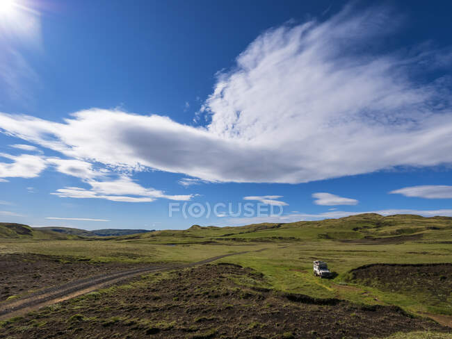 Nubes sobre el remoto camino de tierra islandés en un día soleado - foto de stock