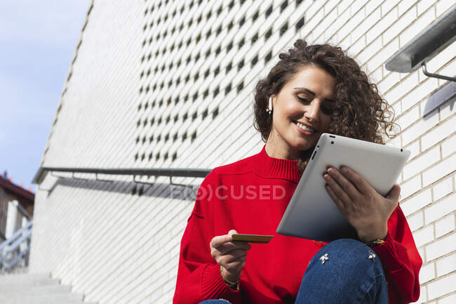 Happy young woman using credit card for shopping online with digital tablet — Stock Photo