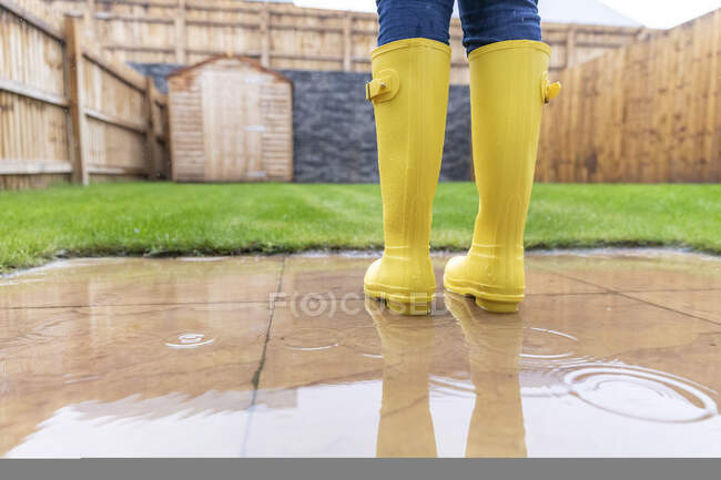 Gros plan de la femme debout dans la cour arrière pendant la saison des pluies — Photo de stock