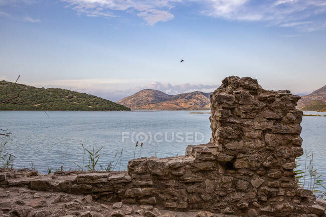 Албанія, округ Влор, Бутрінт, рештки на стародавній стіні на березі озера Бутрінт у сутінках — стокове фото
