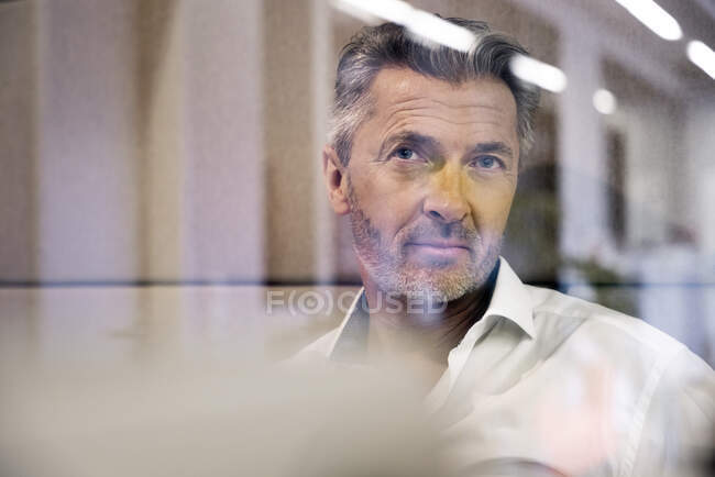 Un uomo d'affari premuroso che distoglie lo sguardo mentre siede in ufficio — Foto stock