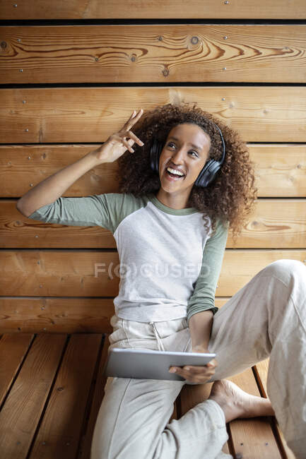 Молодая женщина использует цифровой планшет, сидя дома — стоковое фото
