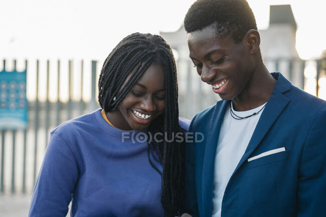 Couple joyeux regardant vers le bas tout en se tenant à l'extérieur — Photo de stock