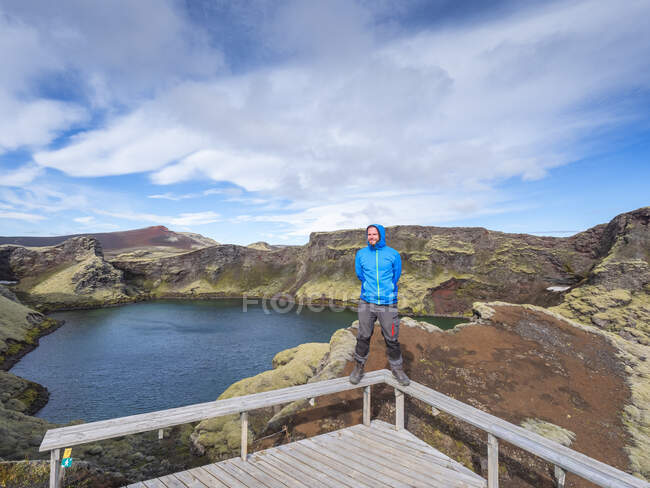 Uomo avventuroso in piedi sulla ringhiera del ponte contro il cielo, Lakagigar, Islanda — Foto stock