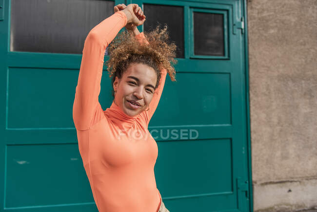 Young woman smiling while dancing against door — Stock Photo