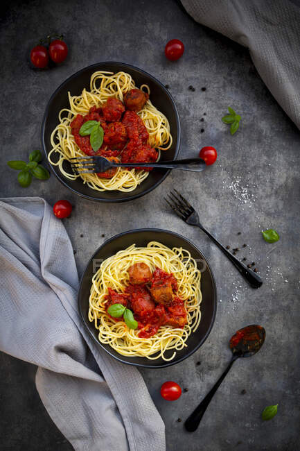 Two bowls of spaghetti with vegetarian polpette and basil — Stock Photo