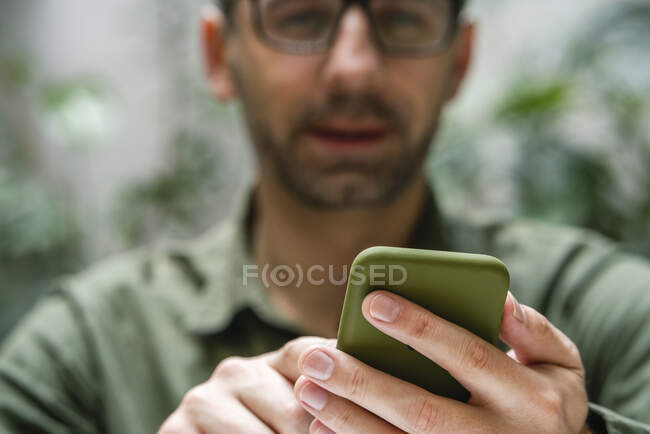 Empresario usando teléfono móvil mientras está sentado en la cafetería - foto de stock