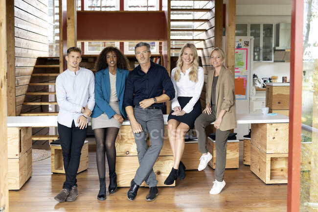Business people smiling while standing together at office — Stock Photo