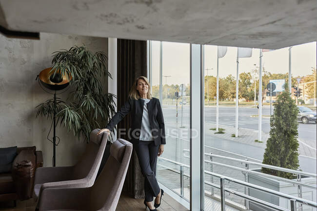 Senior woman standing in lobby — Stock Photo