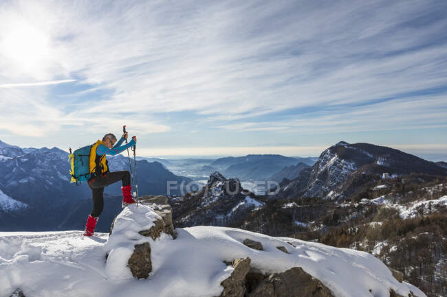 Hombre excursionista escalando en la cima de la montaña contra el cielo, Alpes oróbicos, Lecco, Italia - foto de stock