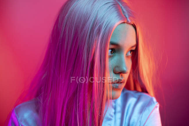 Крупный план вдумчивой молодой женщины в парике на розовом фоне — стоковое фото
