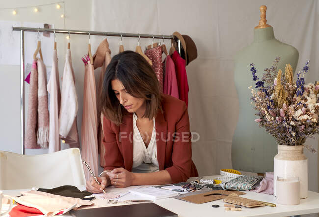 Красивая женщина профессиональный дизайн моды на бумаге на столе в студии — стоковое фото