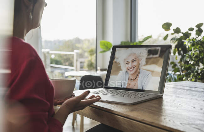 Senior woman smiling on laptop screen during video call — Stock Photo