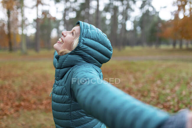 Happy woman with arms outstretched getting wet at Cannock Chase — Stock Photo