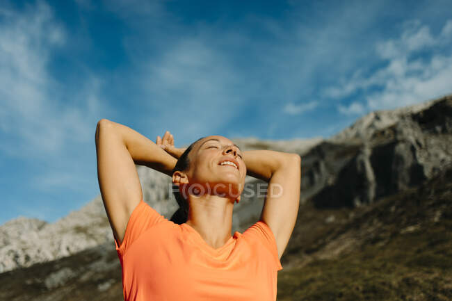 Explorador de pie con las manos detrás de la cabeza contra el cielo en Cares Trail en el Parque Nacional Picos De Europe, Asturias, España - foto de stock
