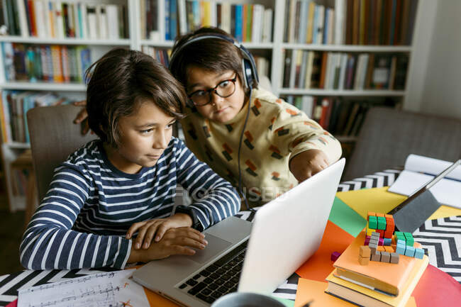 Ragazzi che guardano il computer portatile mentre e-learning in soggiorno — Foto stock