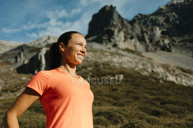 Female explorer smiling while standing against mountain at Cares Trail in Picos De Europe National Park, Asturias, Spain — Stock Photo