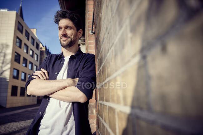 Businessman looking away while leaning on wall — Stock Photo