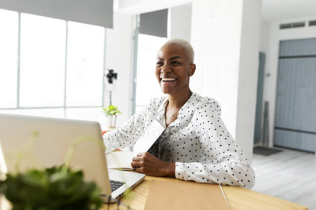 Mujer de negocios sonriente que trabaja en la oficina moderna, utilizando el ordenador portátil - foto de stock