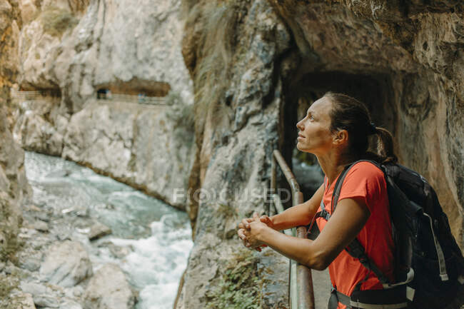 Mujer mirando a la vista mientras está de pie en Cares Trail en el Parque Nacional Picos De Europe, Asturias, España - foto de stock