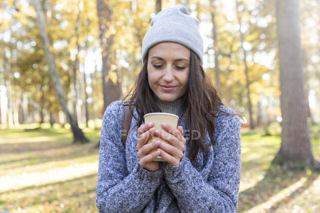 Female hiker holding tea cup in Cannock Chase woodland during winter — Stock Photo