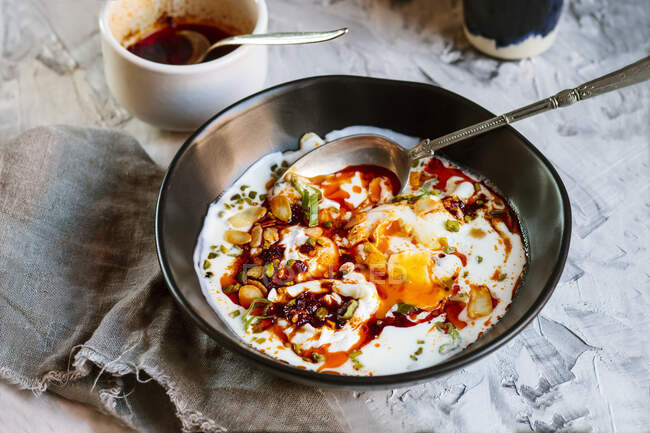 Close-up of yogurt and spicy paprika butter on poached eggs in bowl on table — Stock Photo