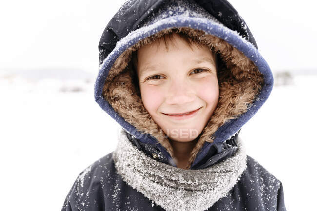Ritratto ravvicinato di un ragazzo sorridente che indossa abiti caldi — Foto stock