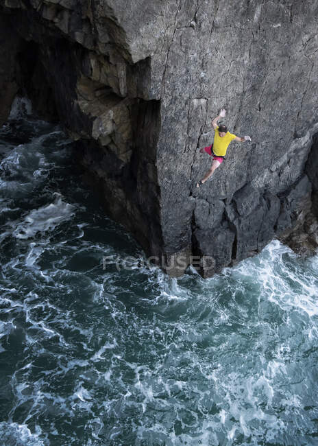 Masculino alpinista salto no mar a partir de penhasco — Fotografia de Stock