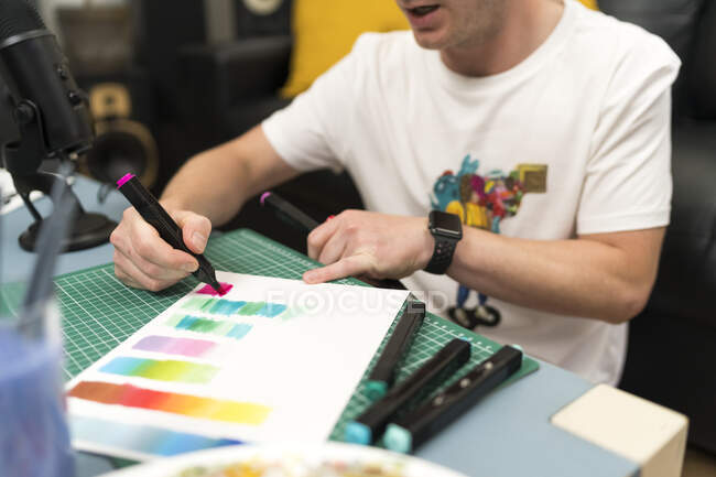 Artiste masculin enseignant le dégradé de couleur à l'aide d'un stylo à coloration en direct à la maison — Photo de stock