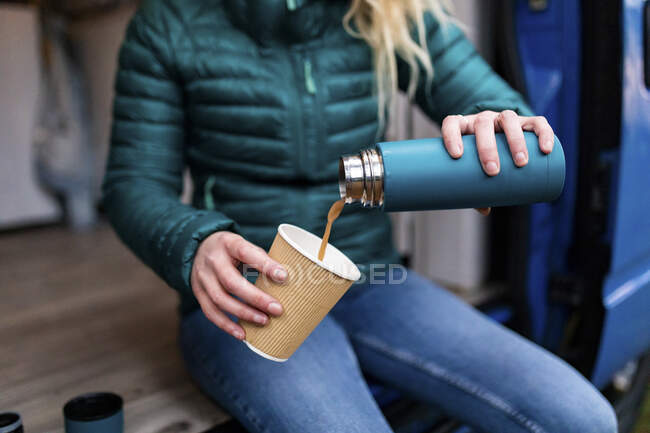 Metà donna adulta versando il tè in tazza usa e getta alla porta del camper — Foto stock