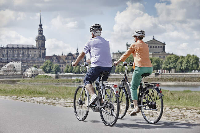 Tourist couple riding electric bicycle at Semper Opera House, Dresden, Germany — Stock Photo