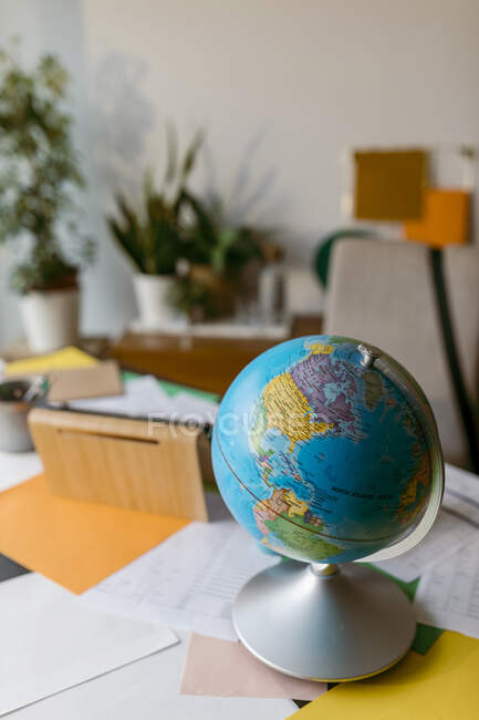 Мировой шар с бумагами на столе — стоковое фото