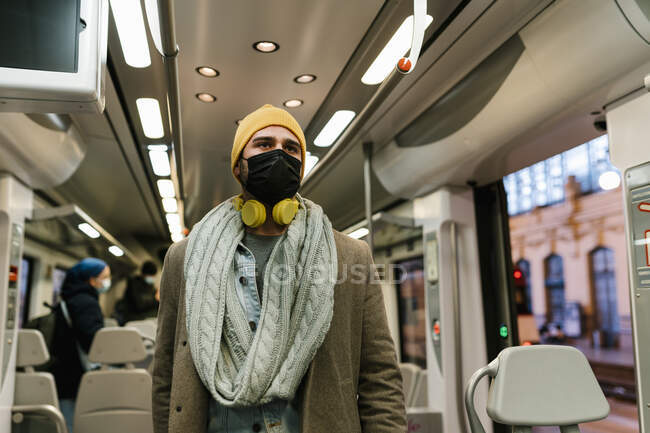 Mann mit Mundschutz schaut im Zug weg — Stockfoto