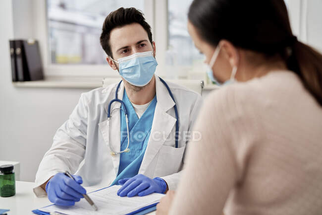 Чоловік, який розмовляє з пацієнтом у клініці. — стокове фото