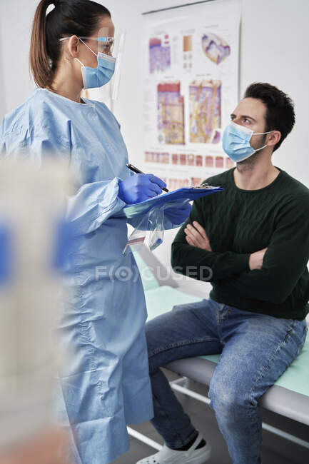 Médecin féminin prenant l'entrevue du patient masculin avant le test médical — Photo de stock