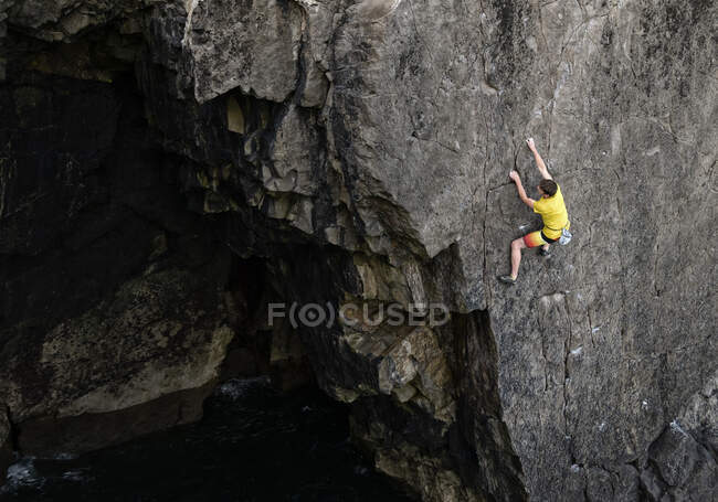 Determinado jovem alpinista do sexo masculino escalada penhasco — Fotografia de Stock